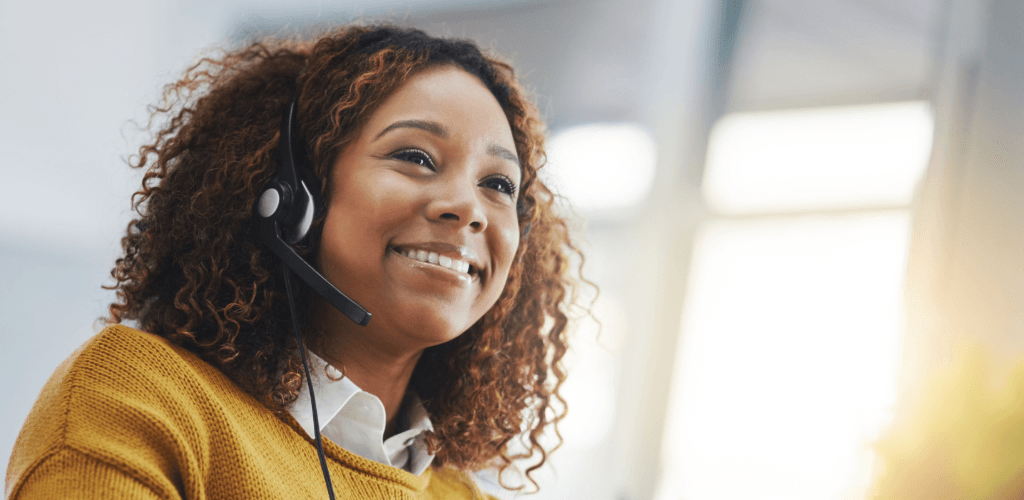 Glad ung kvinna med headset som är redo att svara på telefonsamtal